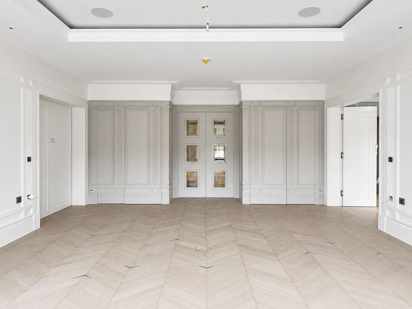 Bright panelled room by Avex with a recessed stretch feature ceiling and chevron parquet flooring