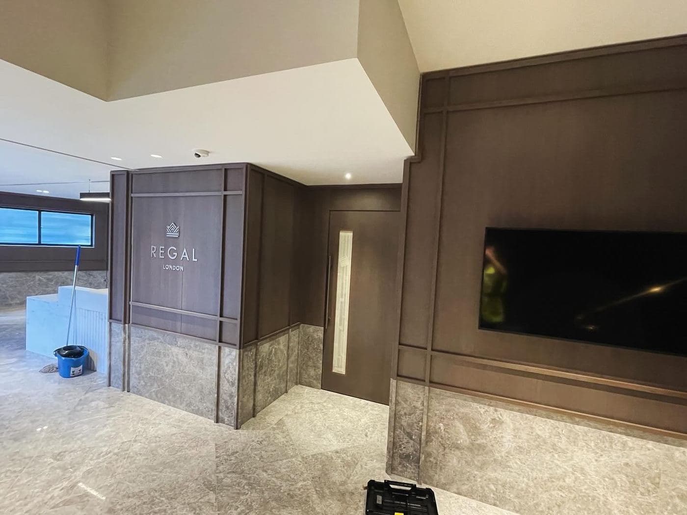 Marble-clad reception with dark timber panelling