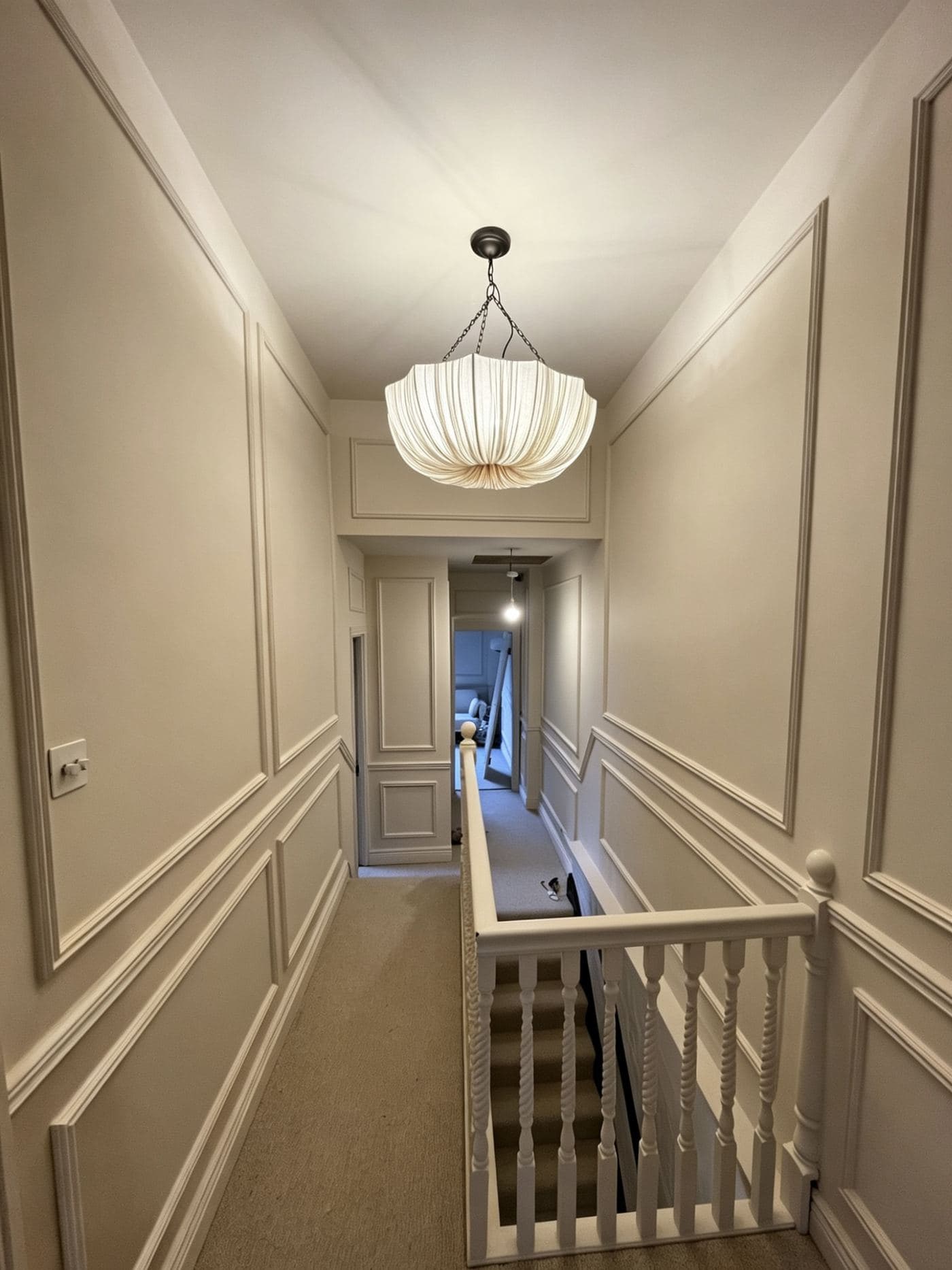 Decorated panelled hallway with pendant lighting