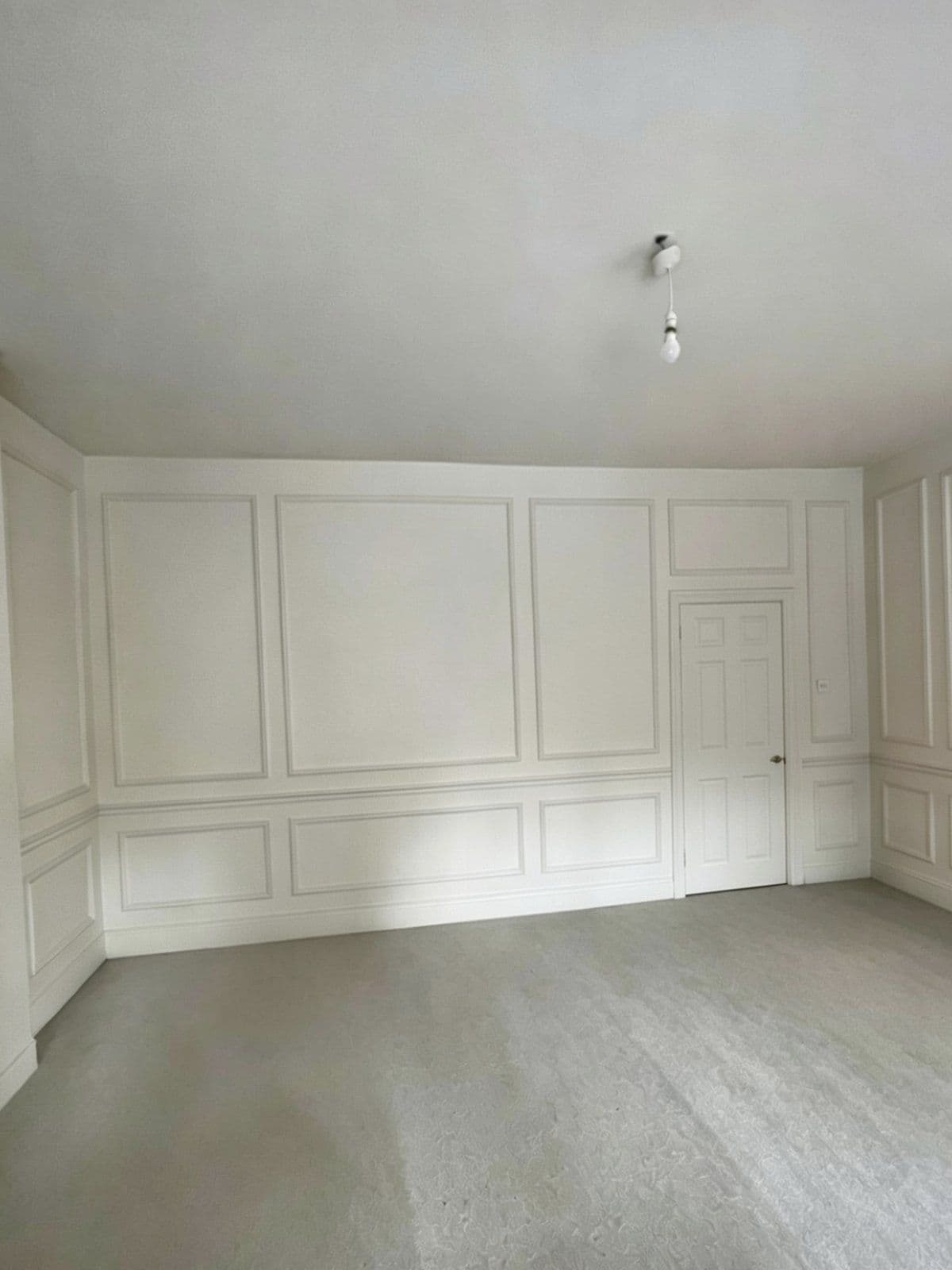 Loft room with full-height wall panelling decorated in white