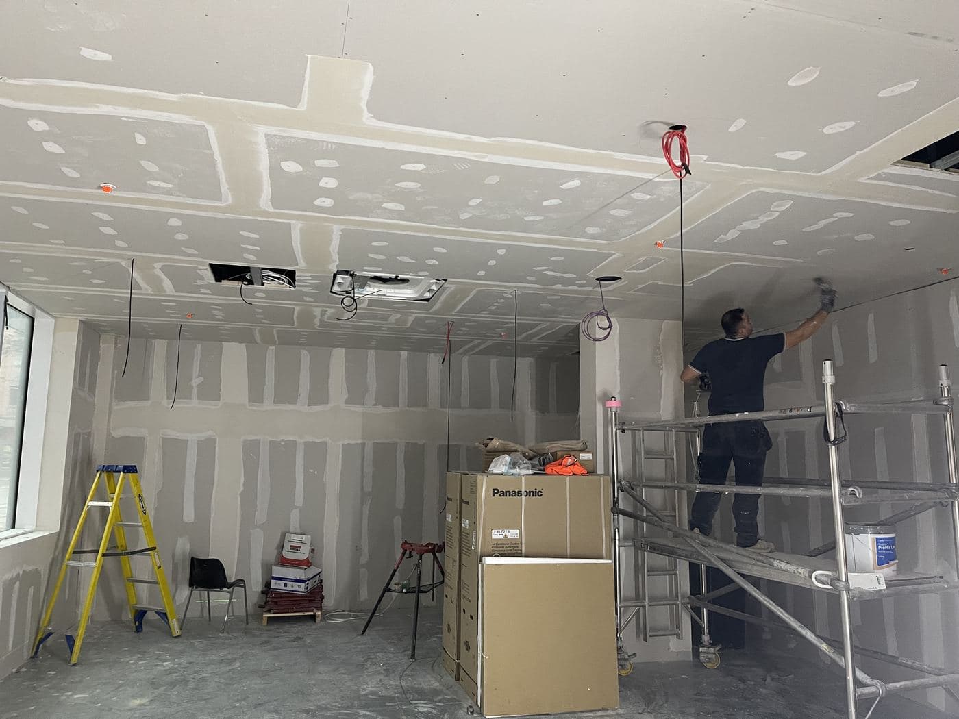 Avex operative taping and jointing plasterboard ceilings on a commercial dry lining project